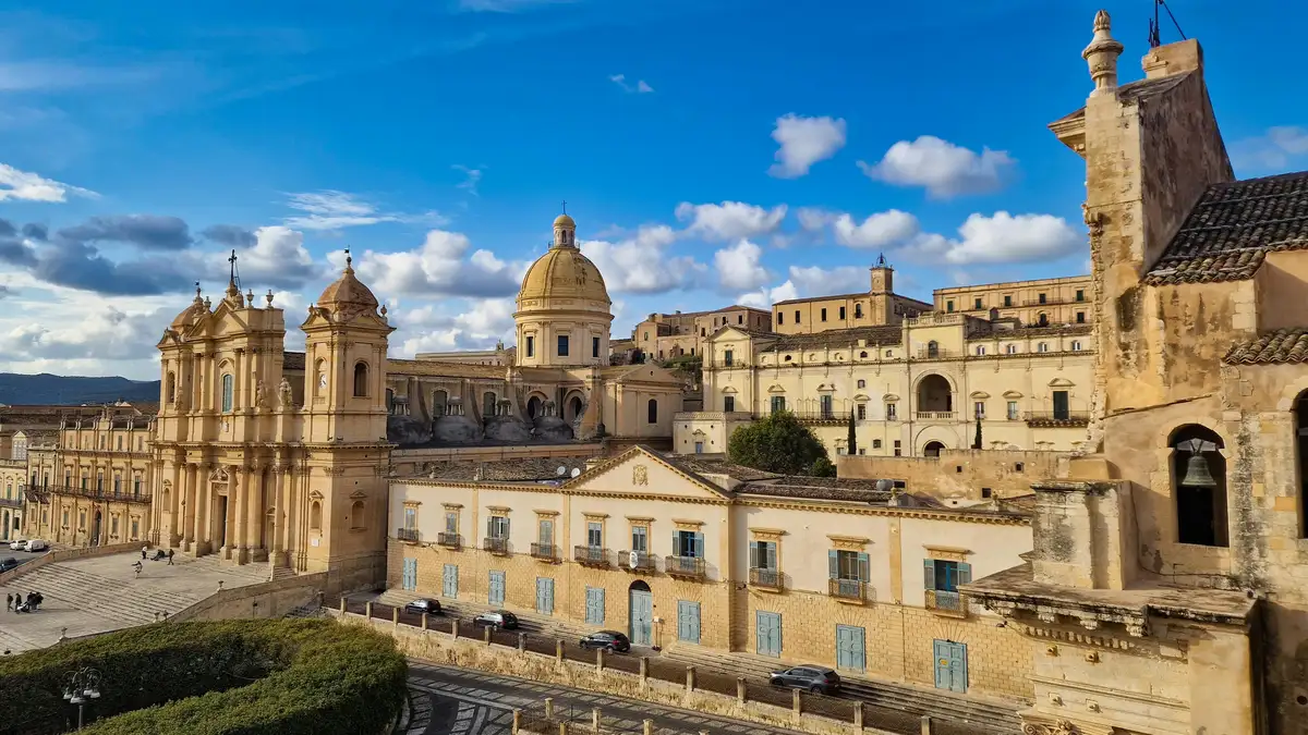 Majestic Noto Cathedral in Val di Noto, Sicily, with ornate baroque facade against a vibrant sky