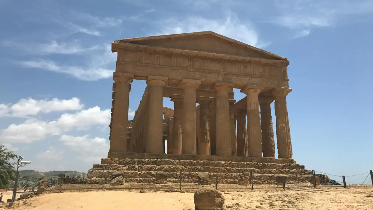 Historic Greek temple ruins under blue sky in Sicily's Valley of the Temples.