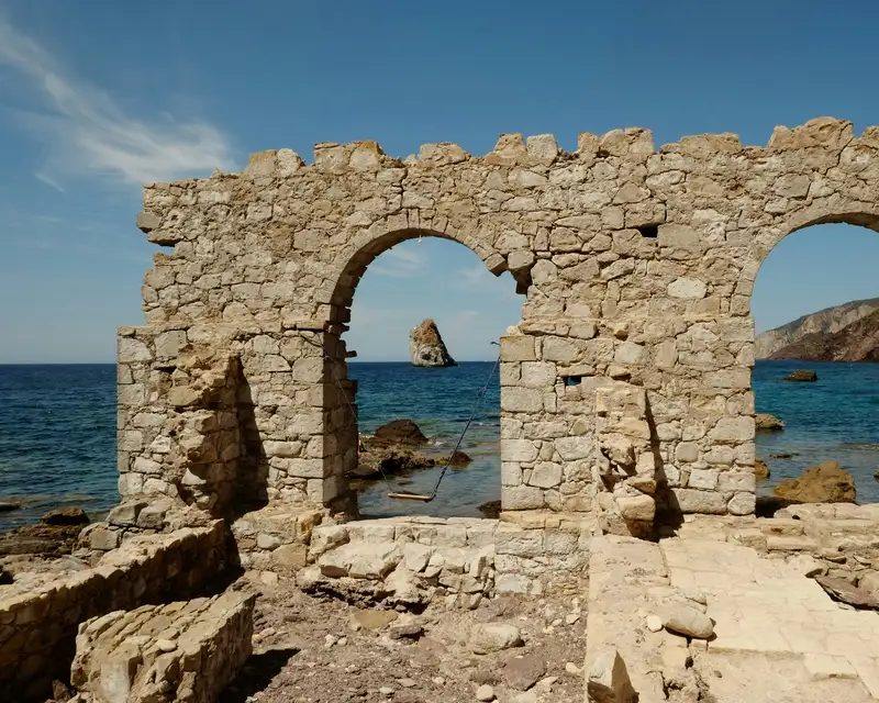 An old stone building sitting on top of a rocky beach